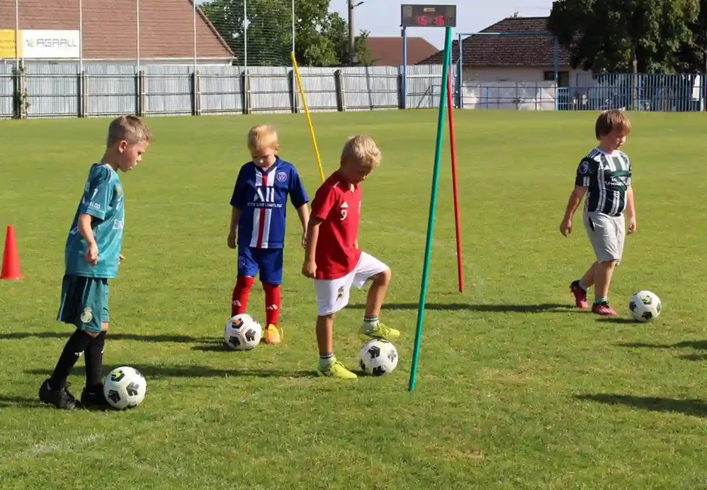 Děti z TJ Sokol Tasovice trénují fotbal na hřišti.