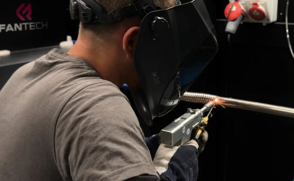 Svářeč navařuje s laserovou svářečkou FANTECH LWG 4.0 EXPERT vlnovec na trubku